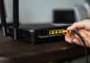 man-plugging-ethernet-cable-wireless-router-scaled.jpg - JurnalDirect
