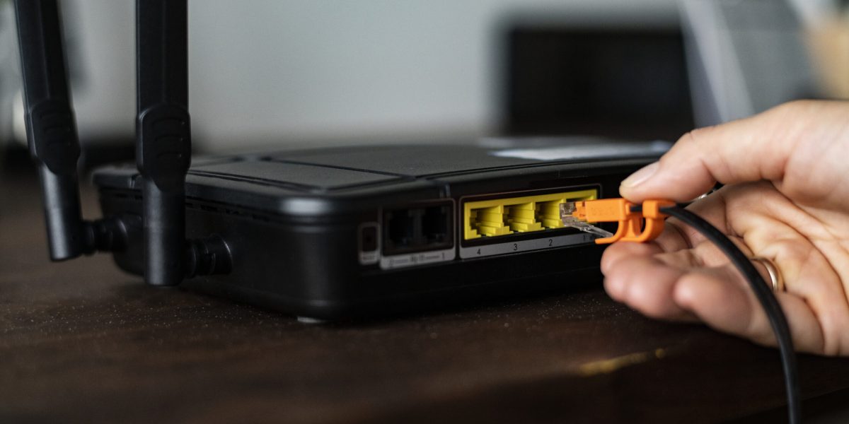 man-plugging-ethernet-cable-wireless-router-scaled.jpg - JurnalDirect